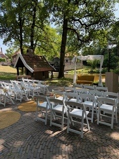 Foto van stoeltjes voor een prieeltje buiten bij De Watermolle