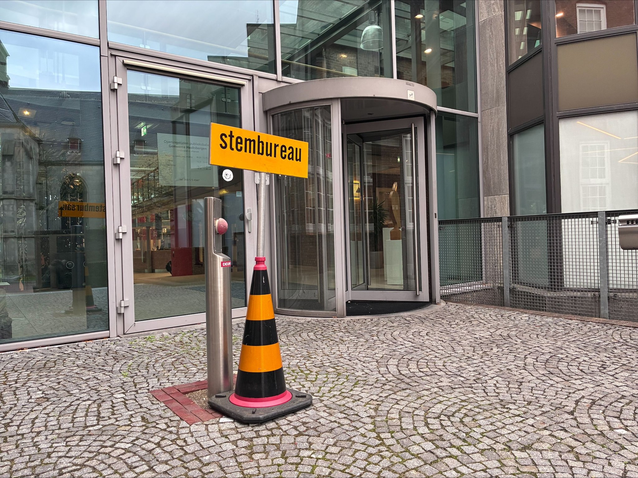 Foto van een bord met stembureau erop voor de ingang van het gemeentehuis aan de kant van de markt. 