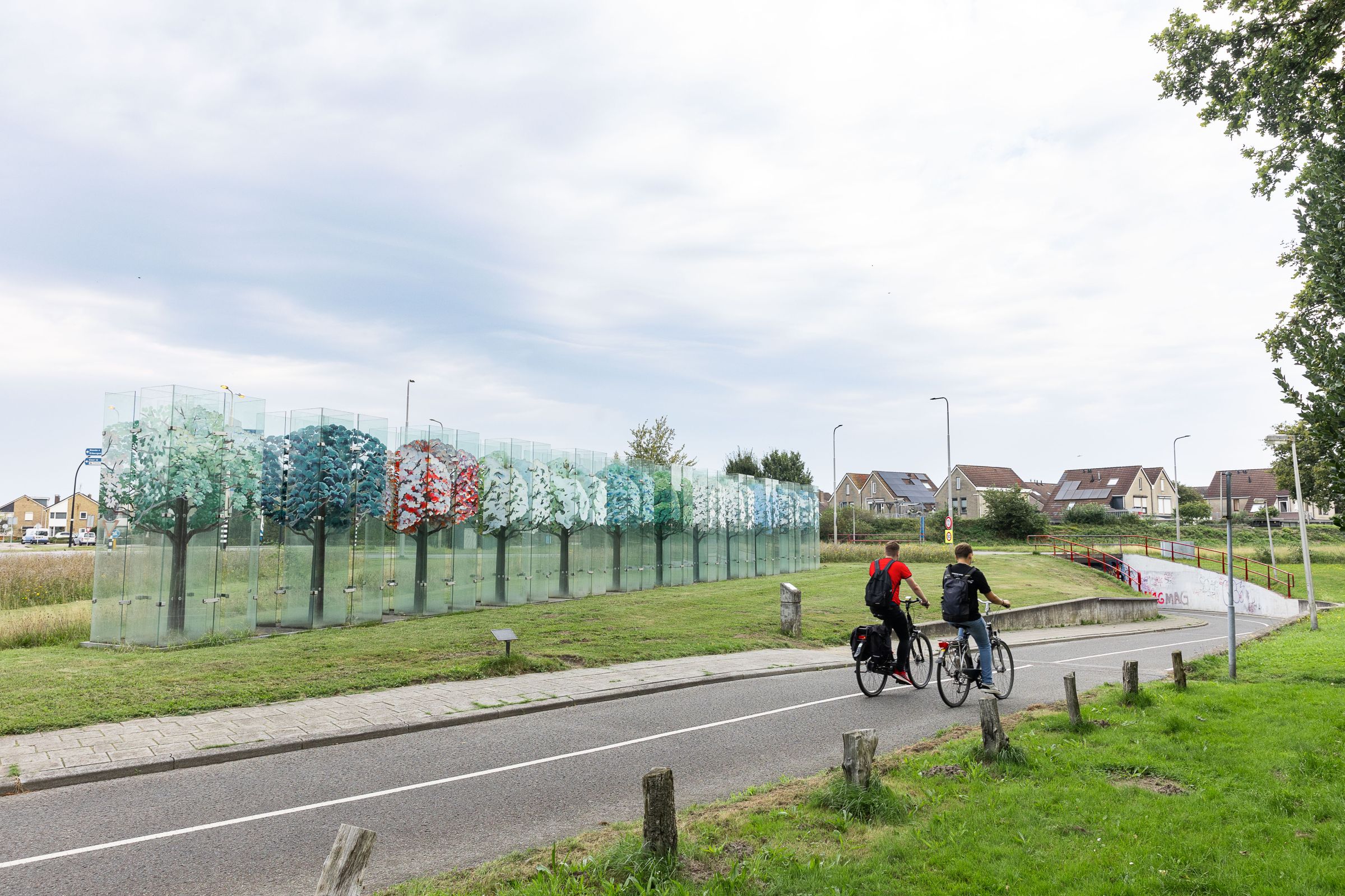 Twee fietsers op fietspad naar fietstunnel naast het Glazen bos. 