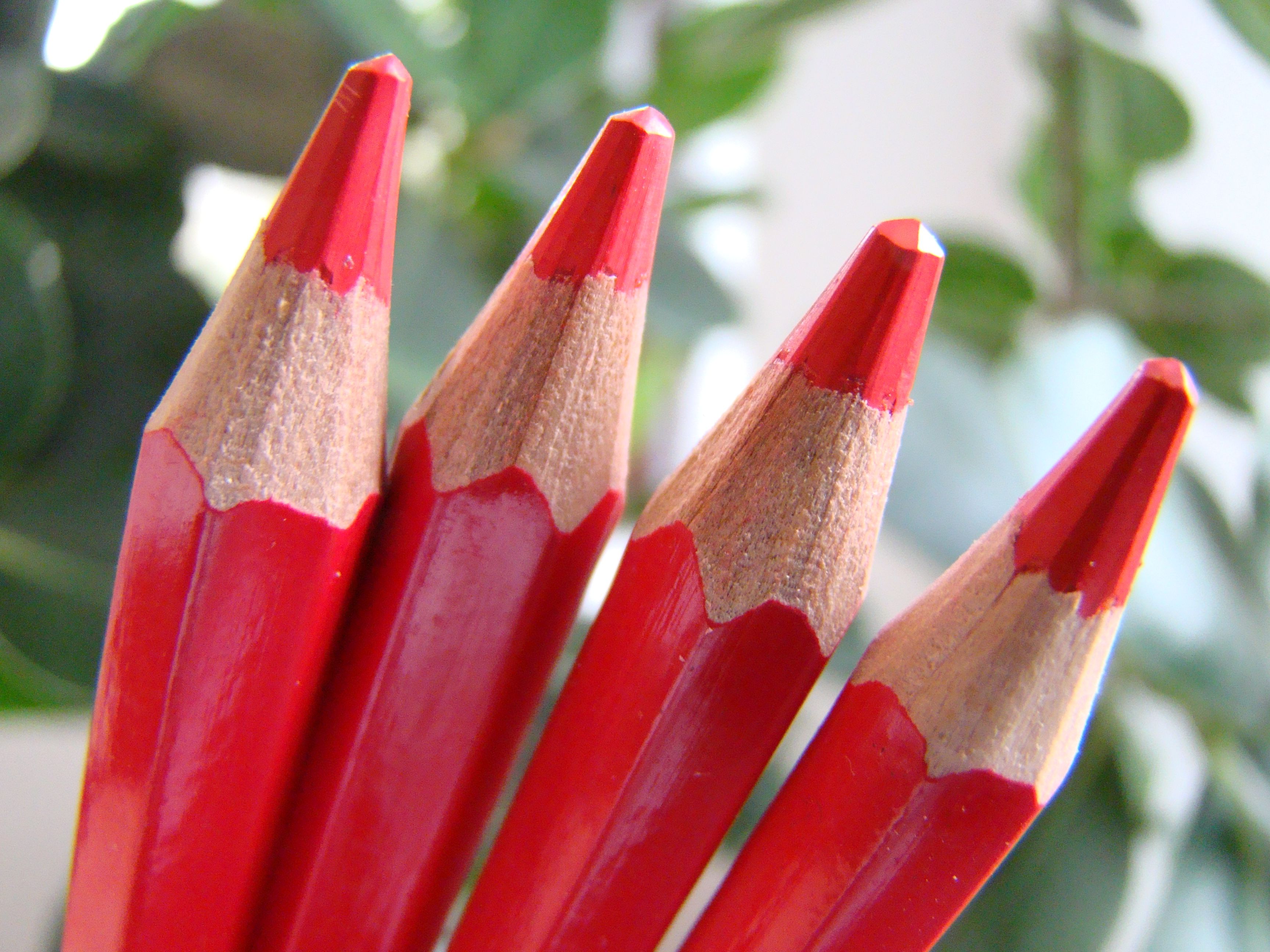 Foto van de bovenkant van vier rode potloden naast elkaar. 
