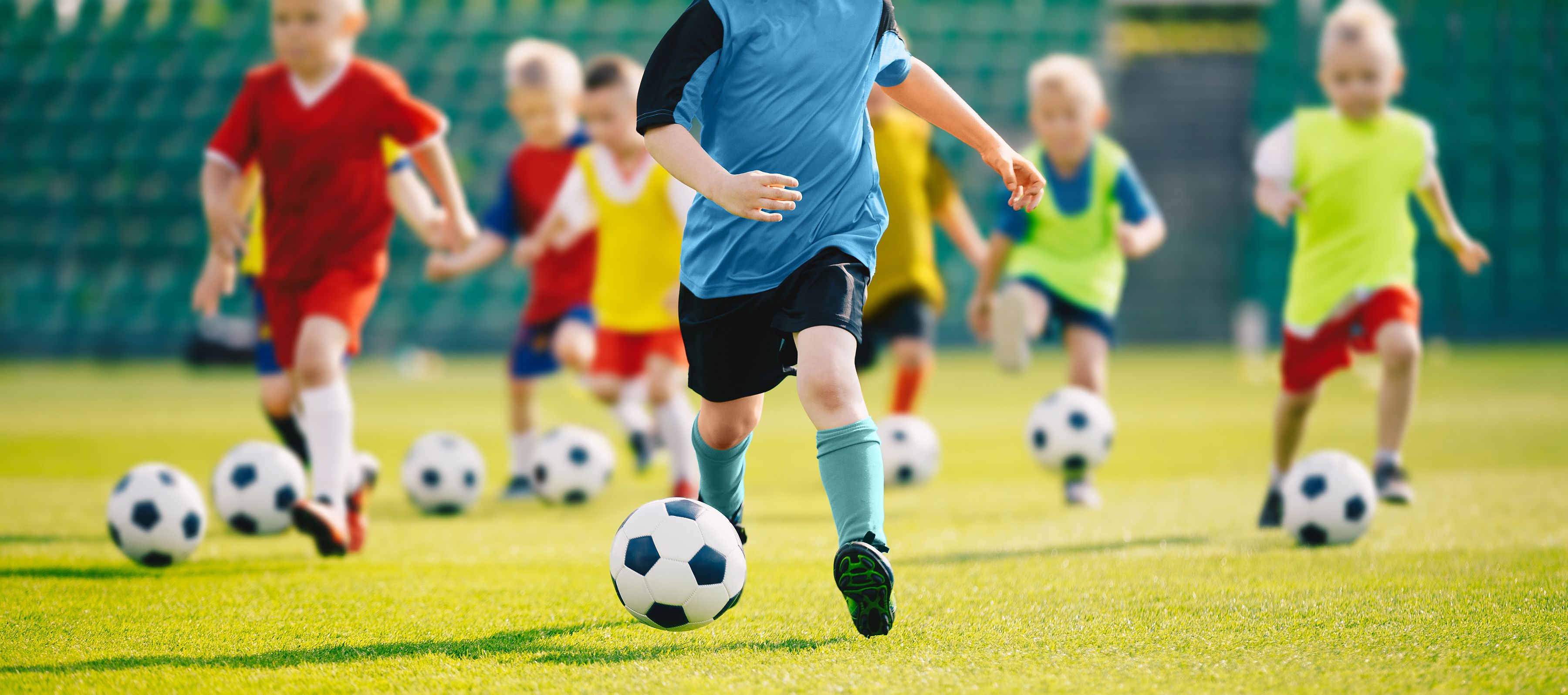 Kinderen die een voetbaltraining doen op een grasveld (stockfoto). 