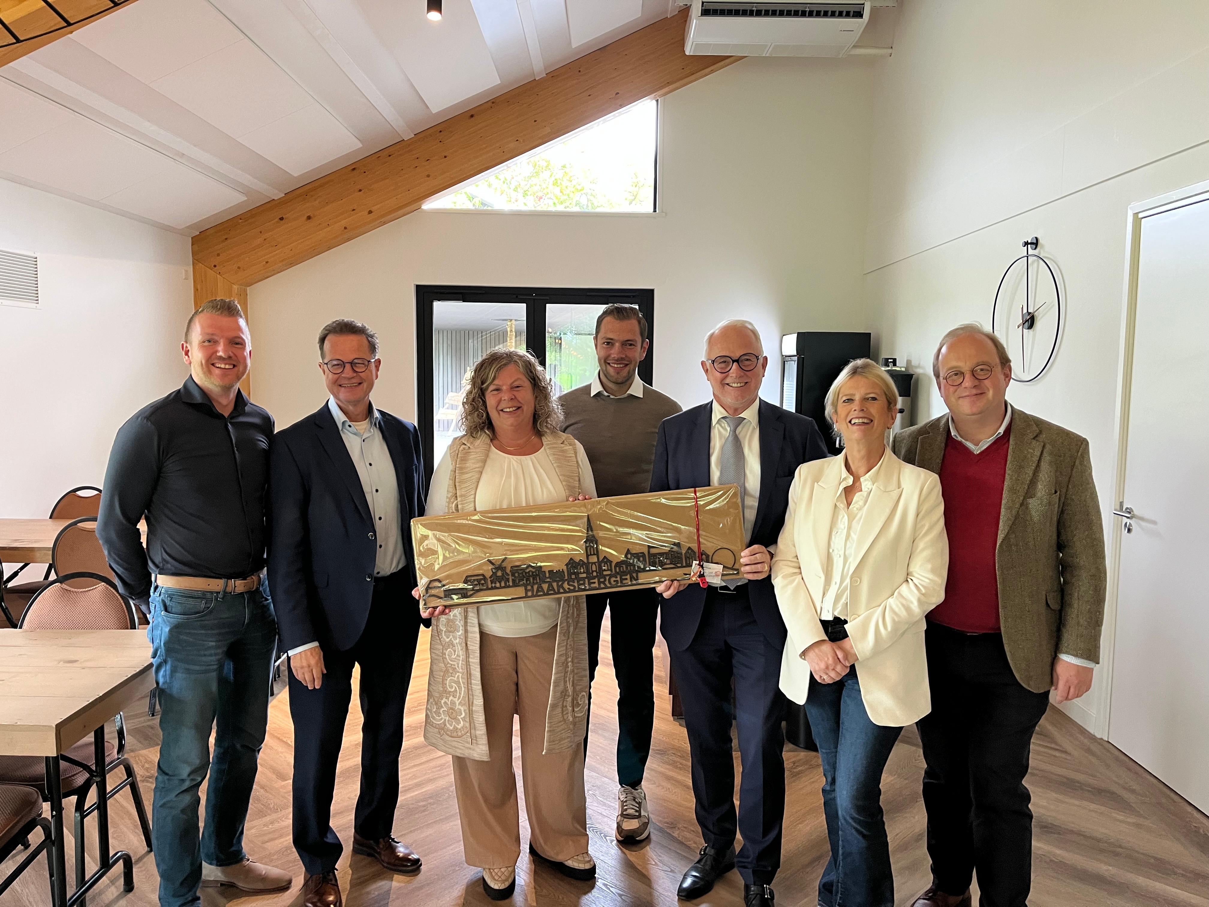 Groepsfoto van afvaardiging gemeente met Esther Startman en zoon Danny Startman. Namens gemeente burgemeester Gerard van den Hengel, wethouders Johan Niemans en Pieter van Zwanenburg, beleidsmedewerker Edwin Wiggers en bestuursondersteuner Angélique Karnebeck. 