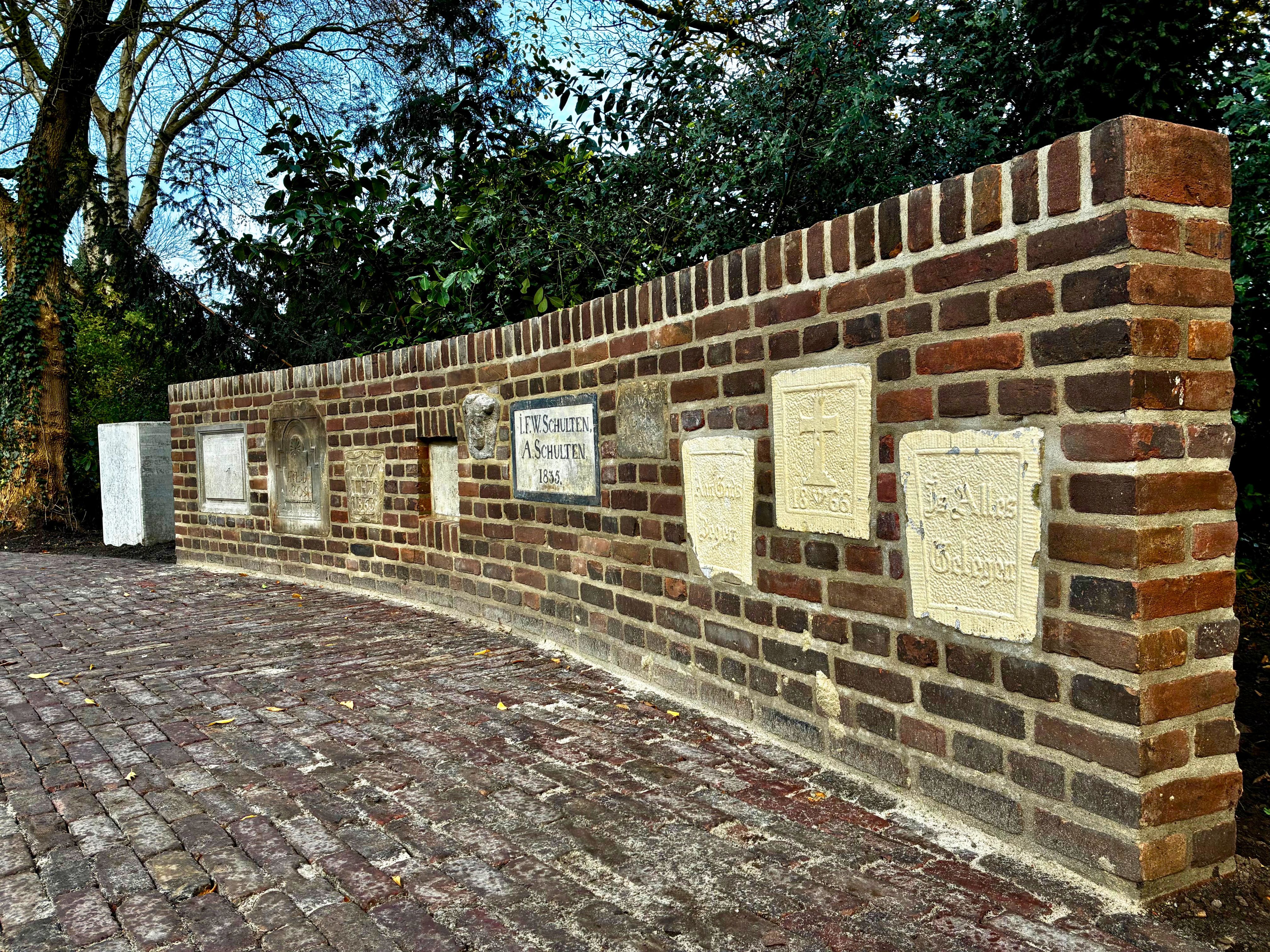 Muur met gevelstenen in de gemeentetuin.