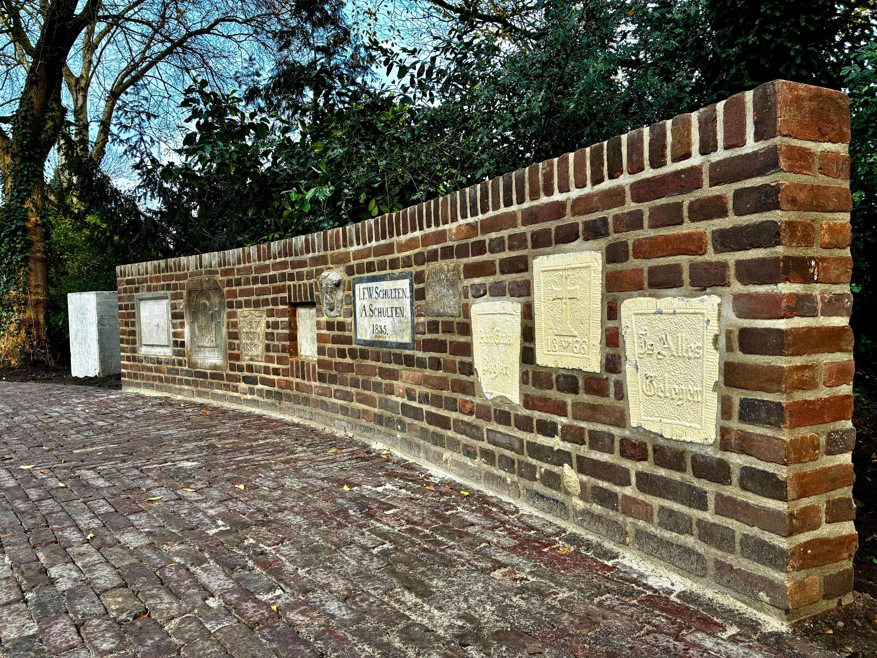 Muur met gevelstenen in de gemeentetuin.