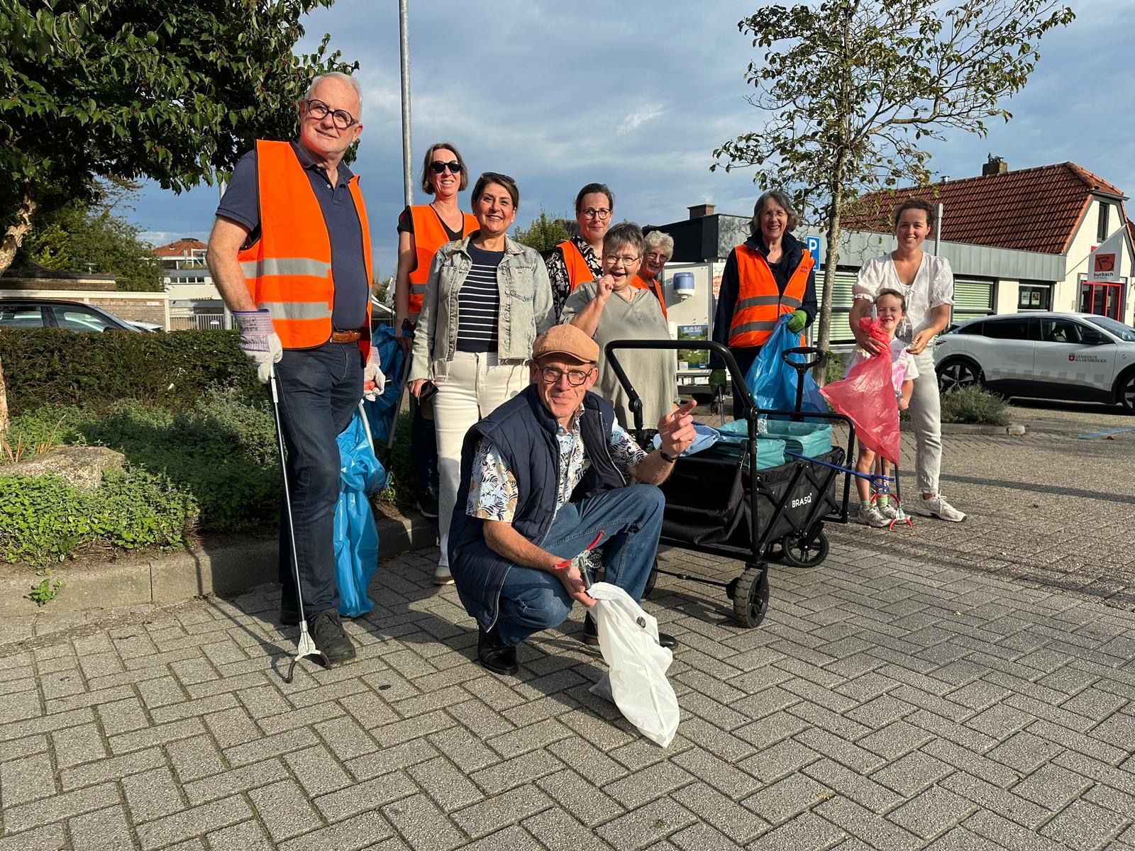 Burgemeester Gerard van den Hengel samen met groep mensen die zwerfafval gaat opruimen. 