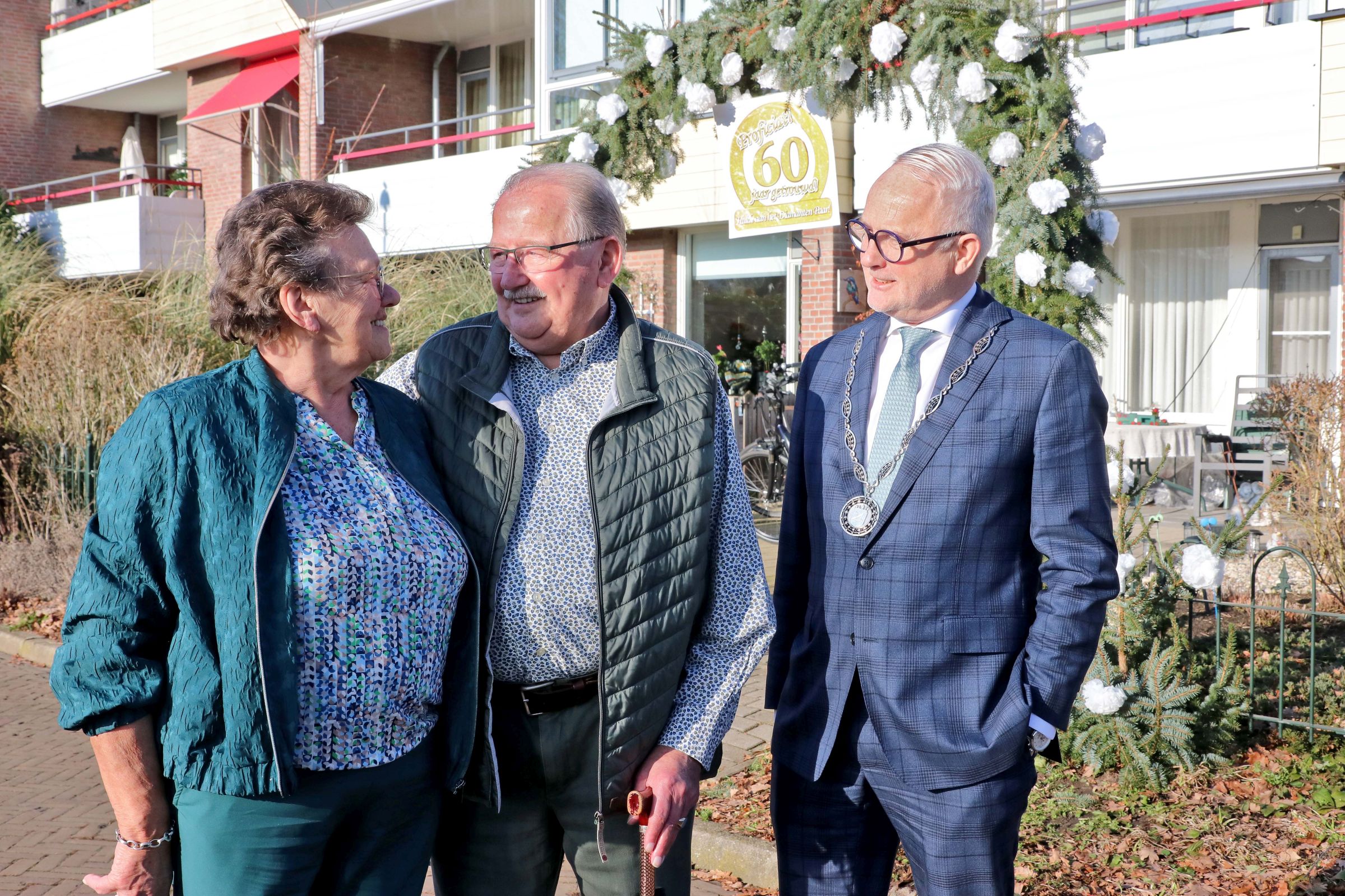 Foto van 60-jarig bruidspaar Hietbrink met burgemeester Gerard van den Hengel.