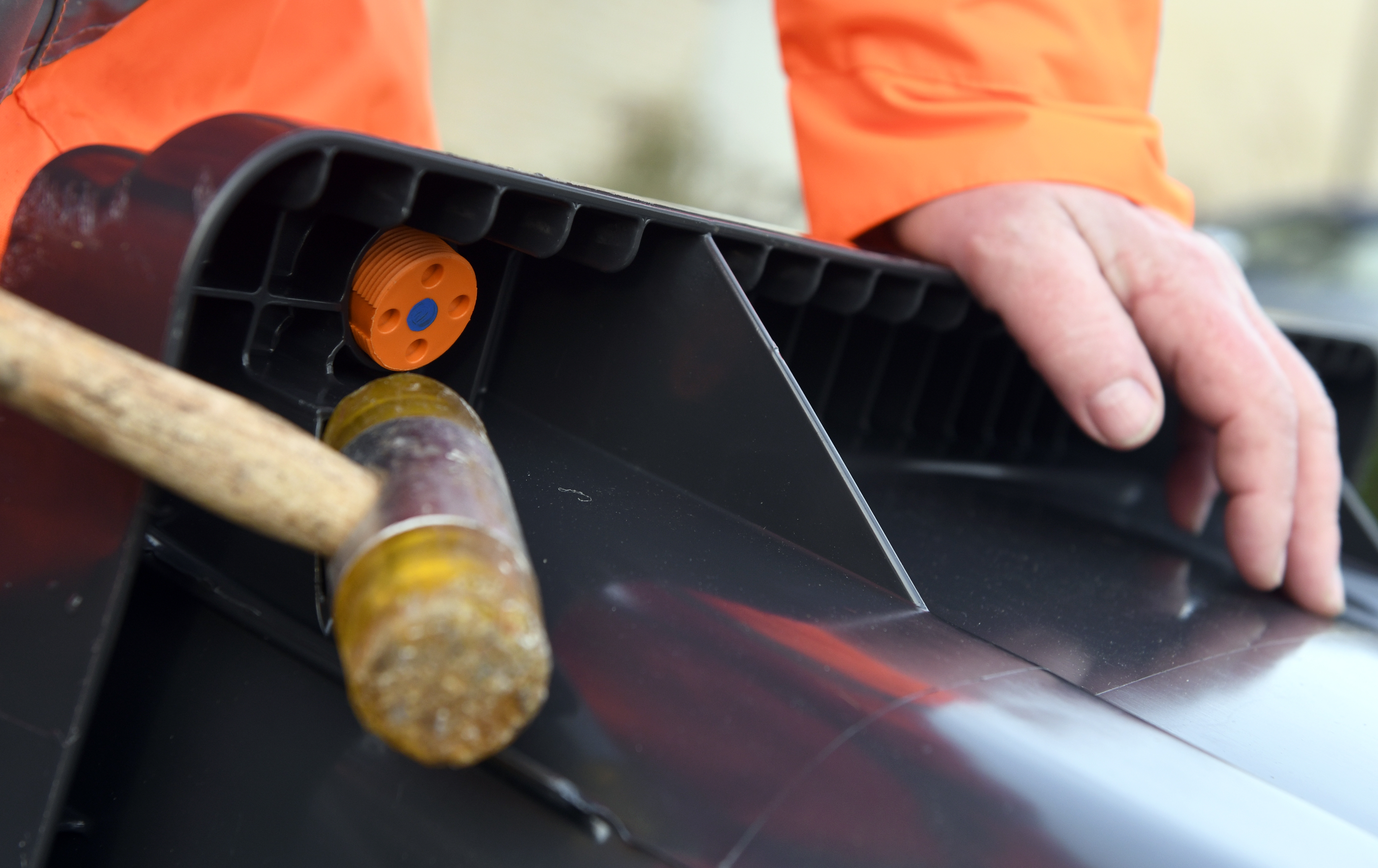 Persoon slaat met een hamer een chip onder de rand van de container.