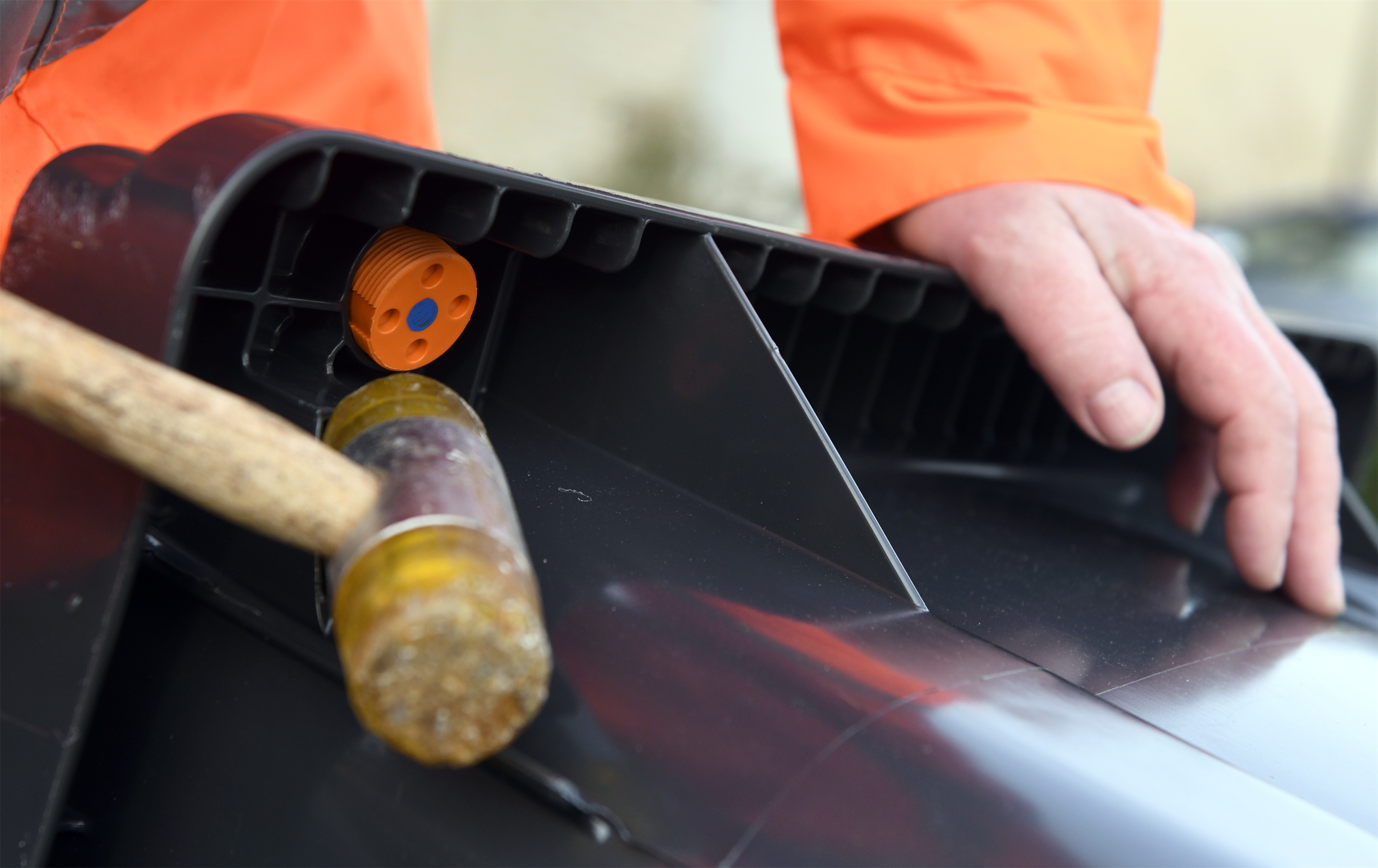 Persoon slaat met een hamer een chip onder de rand van de container.