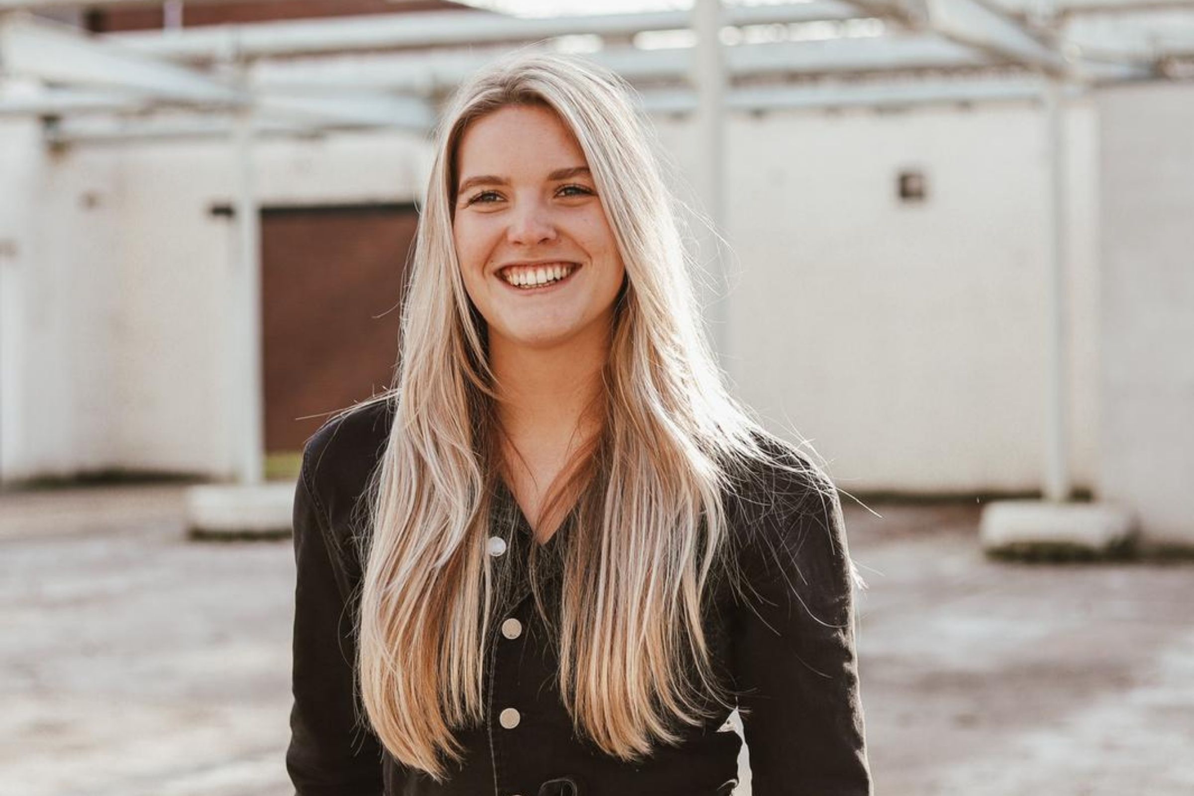 Portretfoto van een vrouw met blond haar in een lege hal.