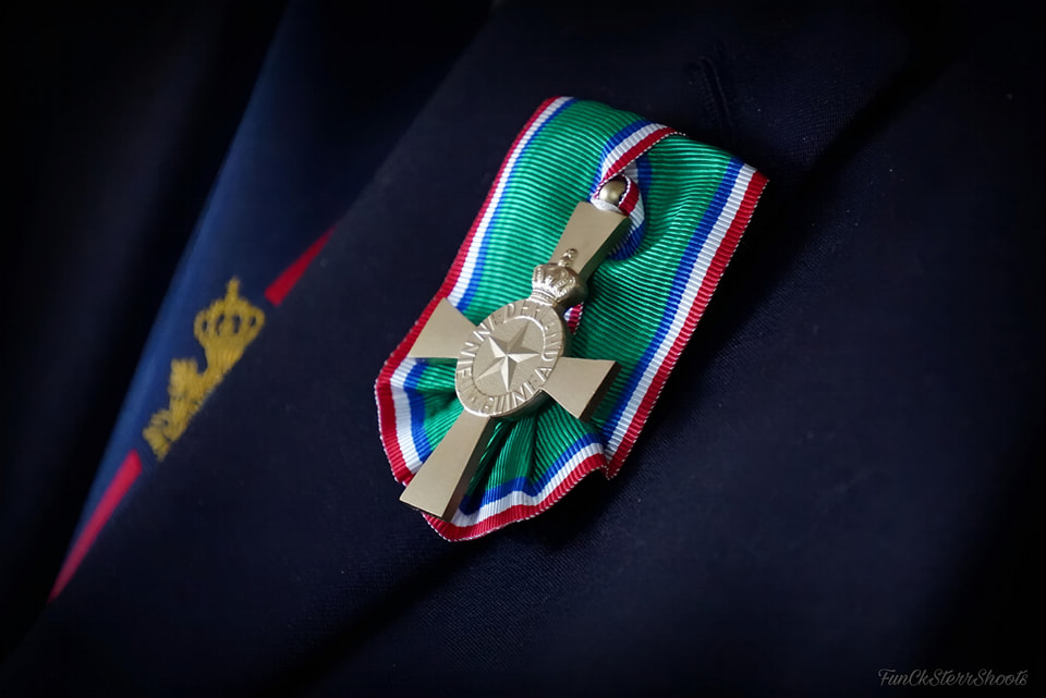 Foto van het ereteken voor Nieuw-Guinea veteranen opgespeld op de rever van een donkerblauwe blazer.