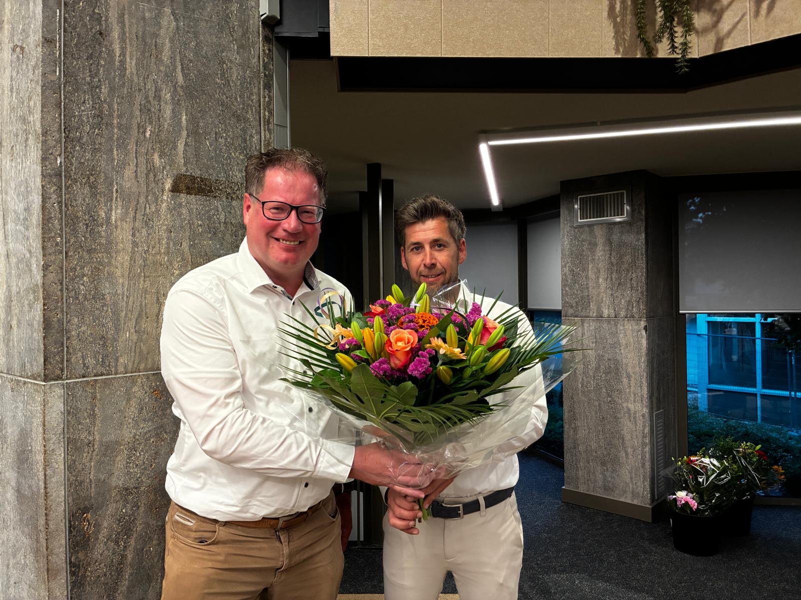 Jan-Herman Scholten krijgt bloemen van Jeroen Slot.