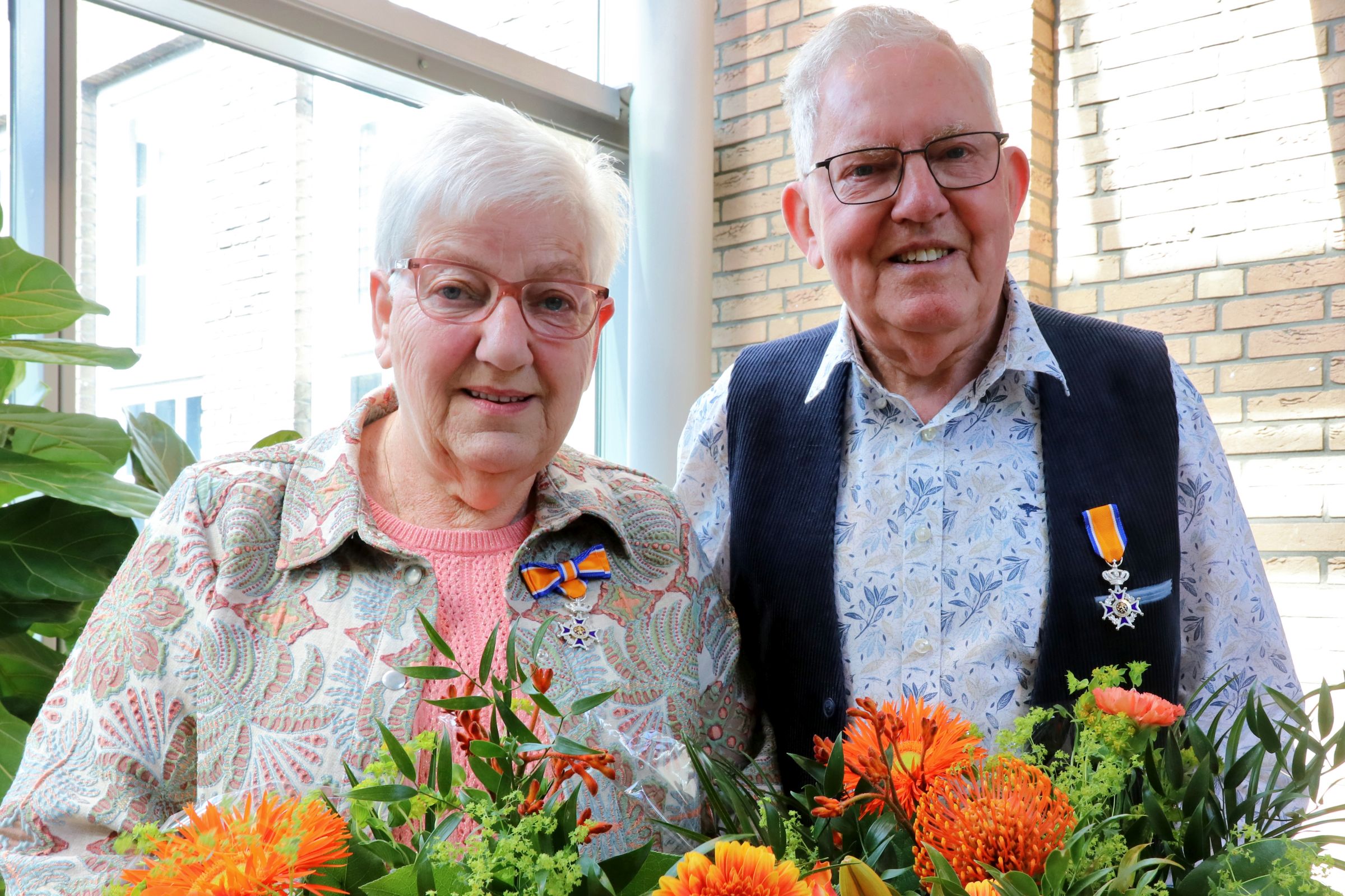 Foto van Femie en Joop Oosterkamp naast elkaar met beide een bos bloemen in de hand