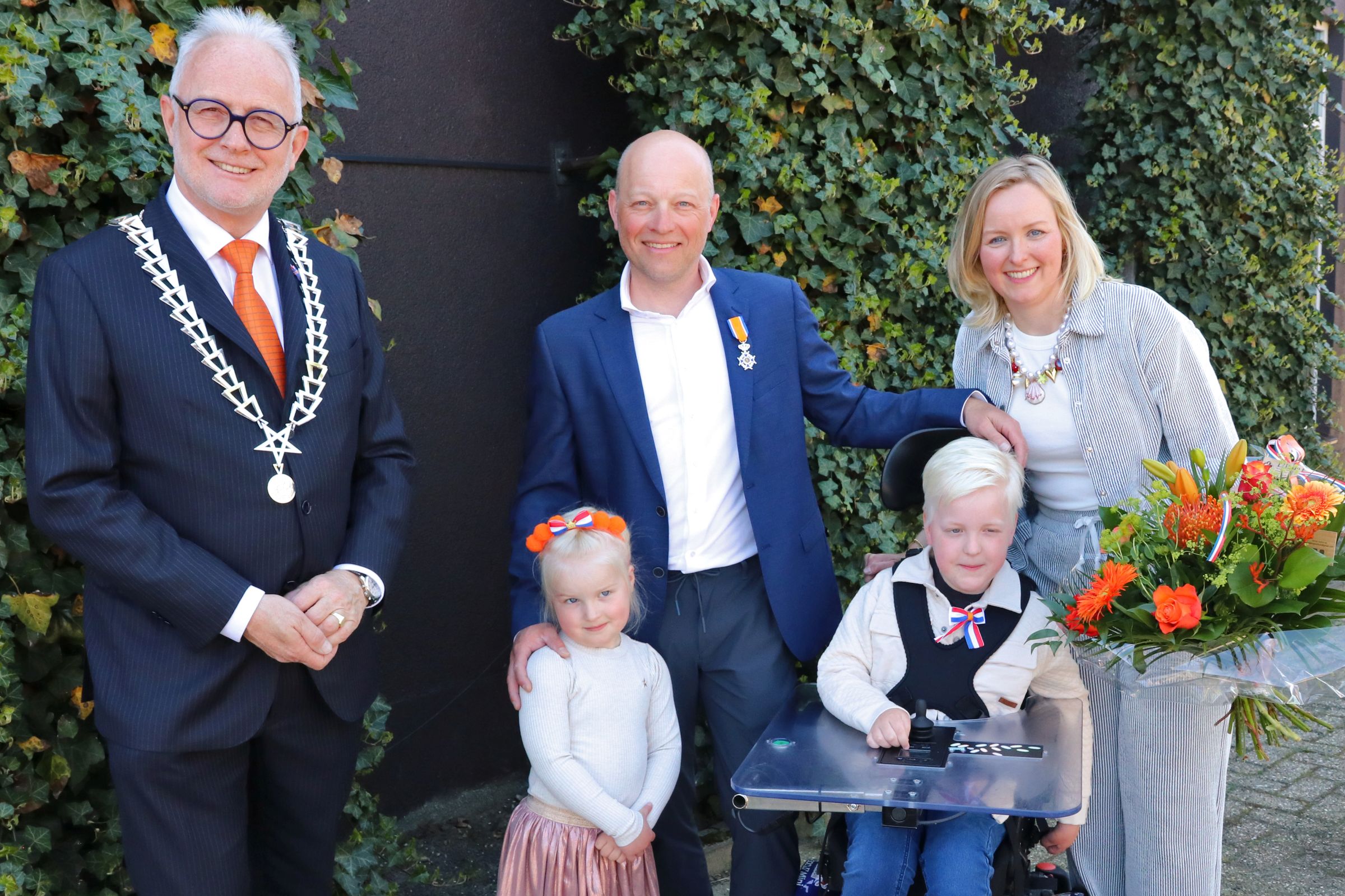 Foto van Thijs Rupert, zijn vrouw en twee kinderen en burgemeester Gerard van den Hengel.
