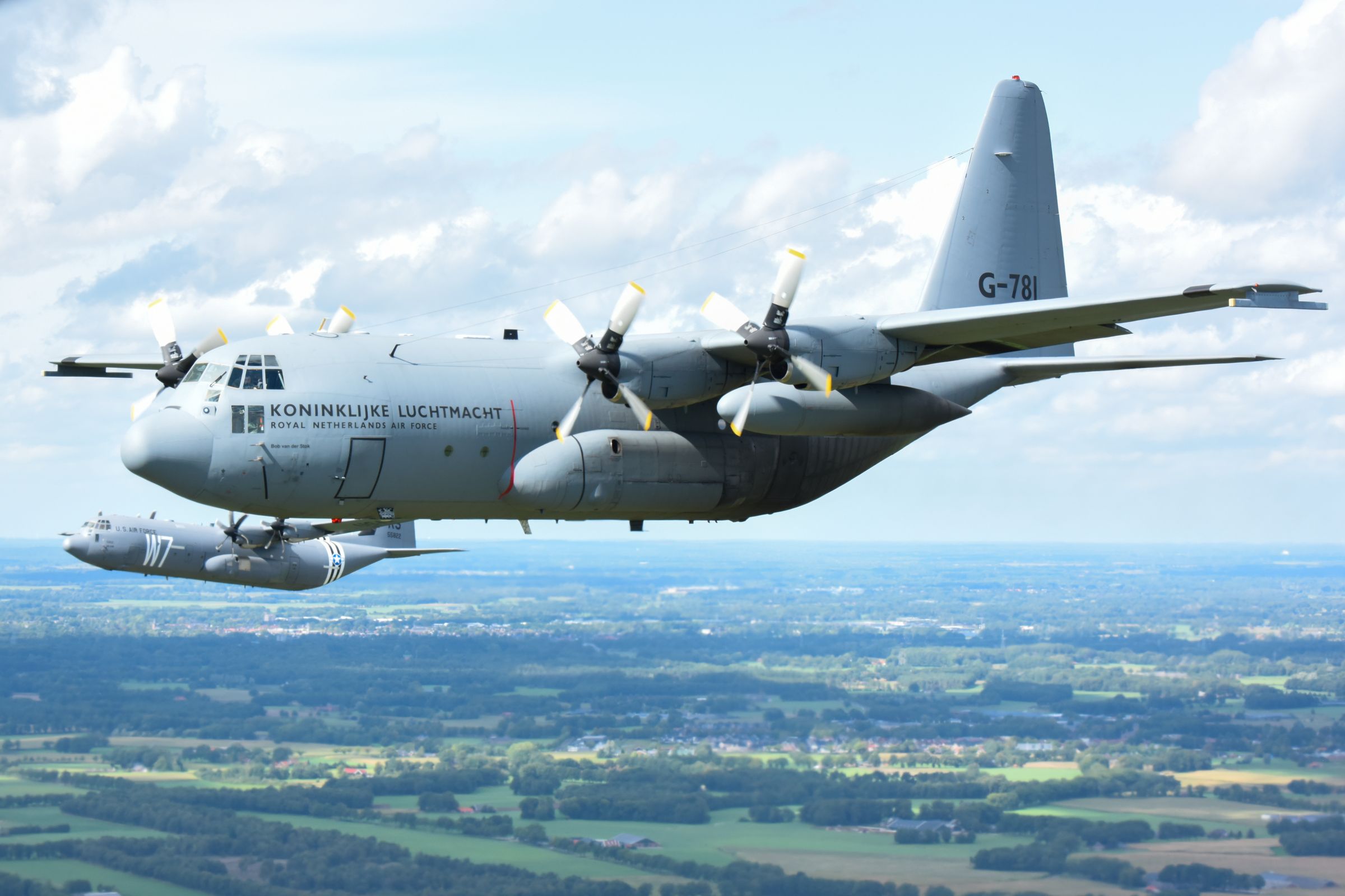 Foto van een militair vliegtuig in de lucht.