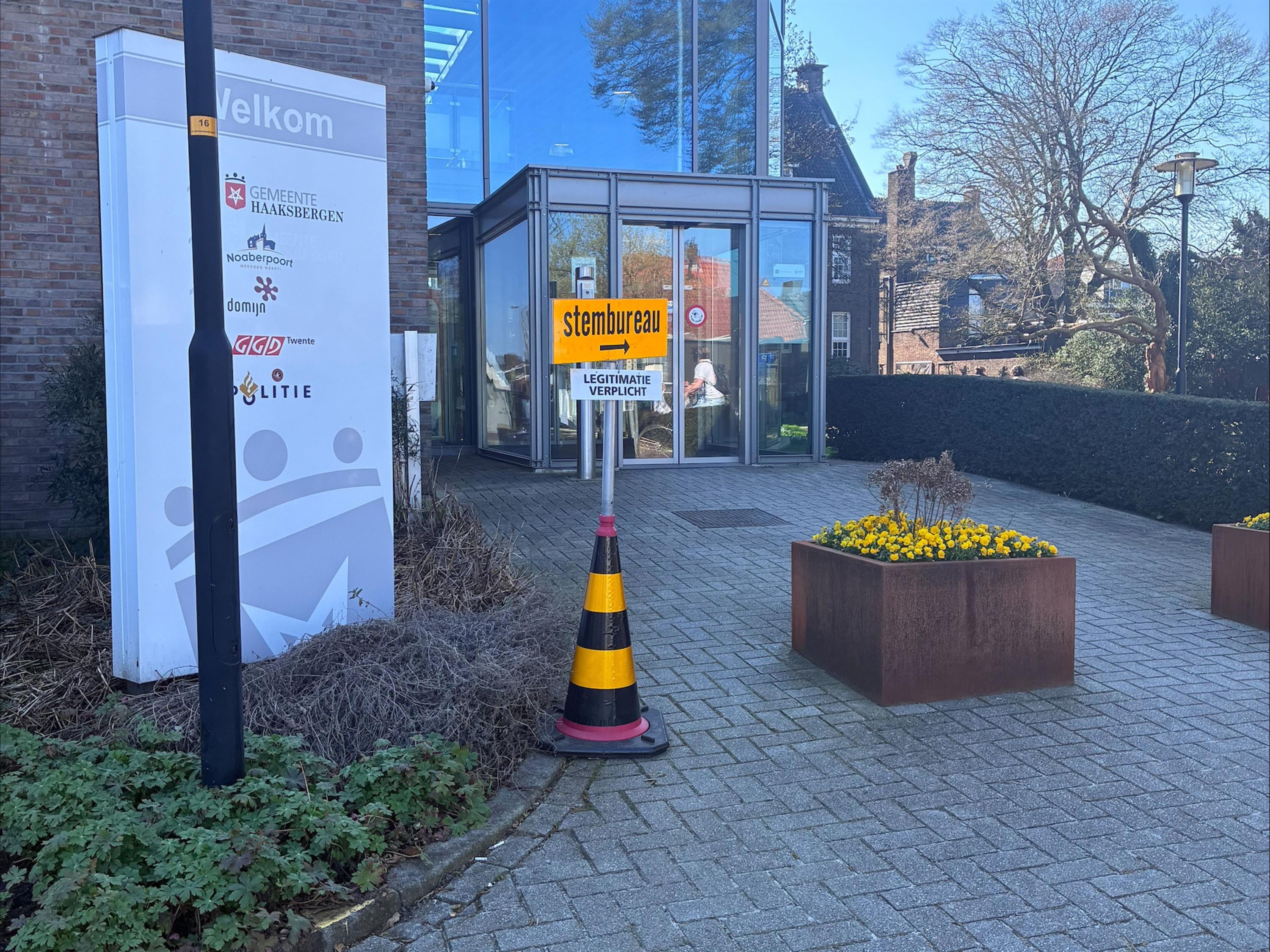 Foto van een stembureaubord voor de ingang van het gemeentehuis.