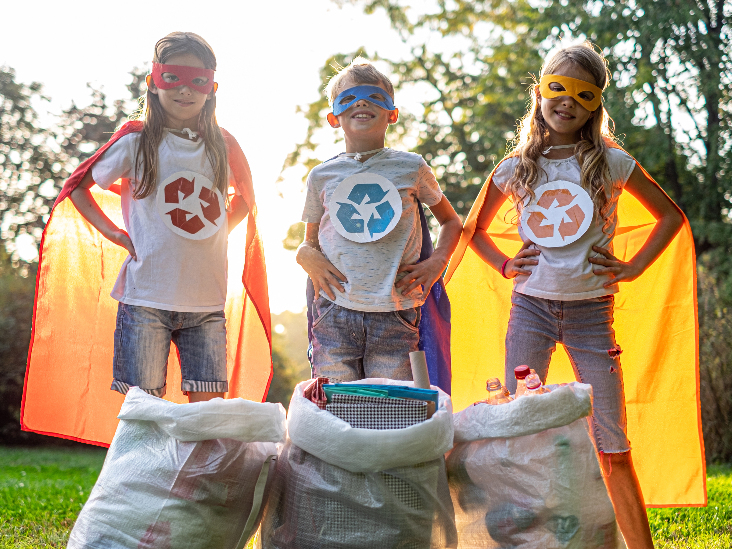 Drie kinderen die verkleed zijn als recycle-superhelden.